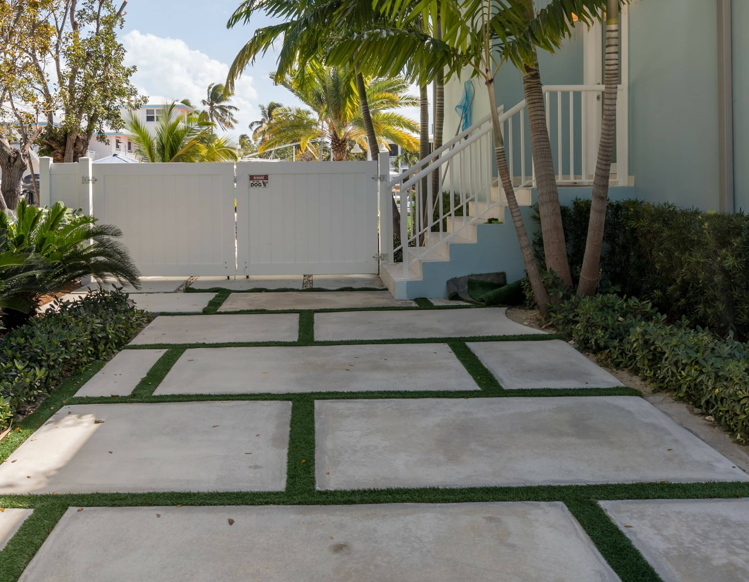 Modern Concrete slabs separated by grass in driveway with white